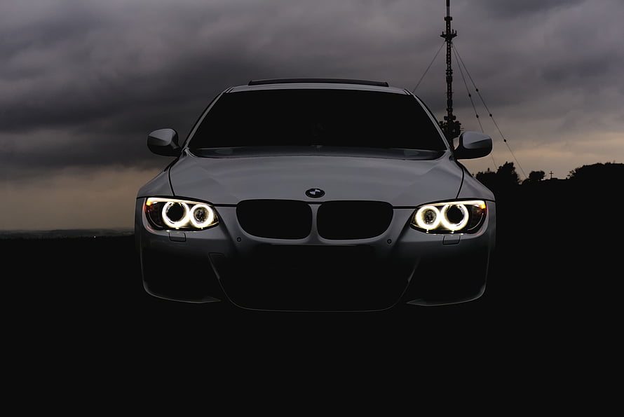 BMW M3 Front View With Glowing Headlights Under Dramatic Overcast Sky HD wallpaper