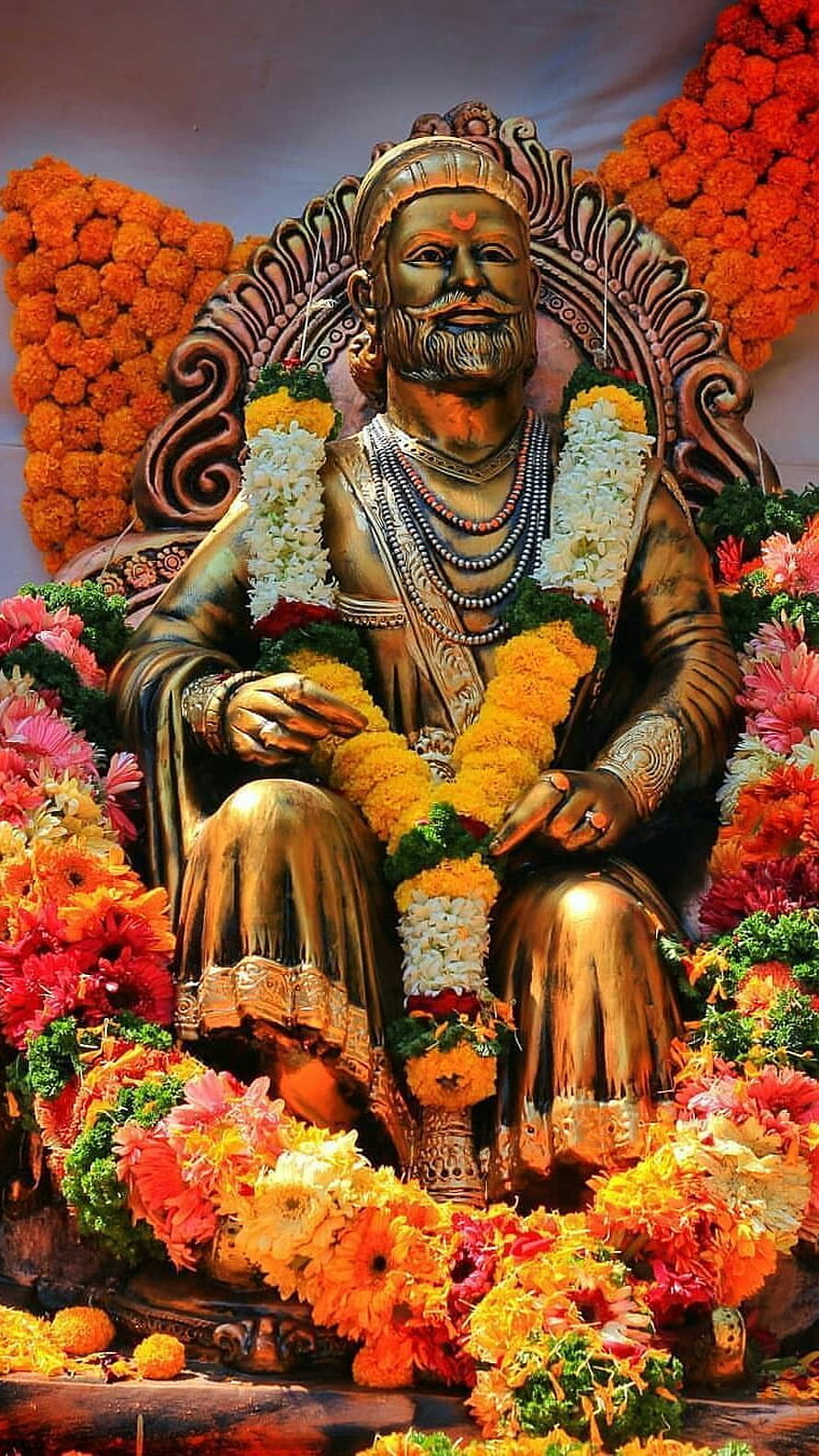 Golden Statue of Shivaji Maharaj Adorned with Vibrant Marigold and Jasmine Flower Garlands HD phone wallpaper
