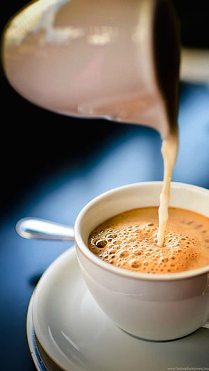 Pouring Steamed Milk Into A Frothy Coffee Cup On A Blue Table HD phone wallpaper