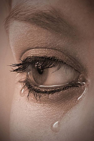 Close-up of a teardrop rolling down a cheek from a glistening brown eye HD phone wallpaper