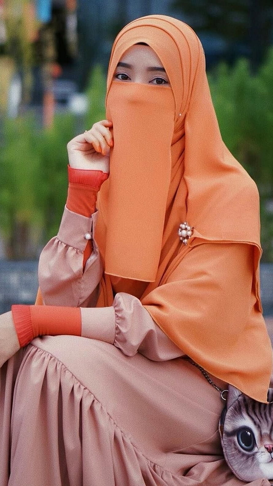 Elegant Woman in Orange Hijab and Modest Abaya with Cat Purse HD phone wallpaper