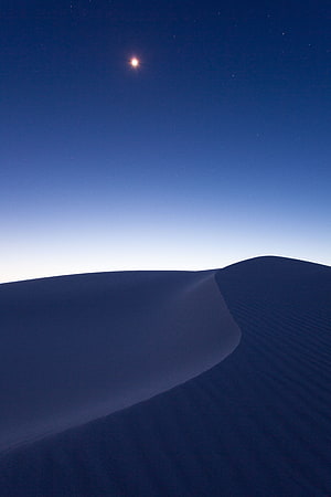 Minimalist Desert Dunes Under a Starry Night Sky with a Bright Celestial Body HD phone wallpaper
