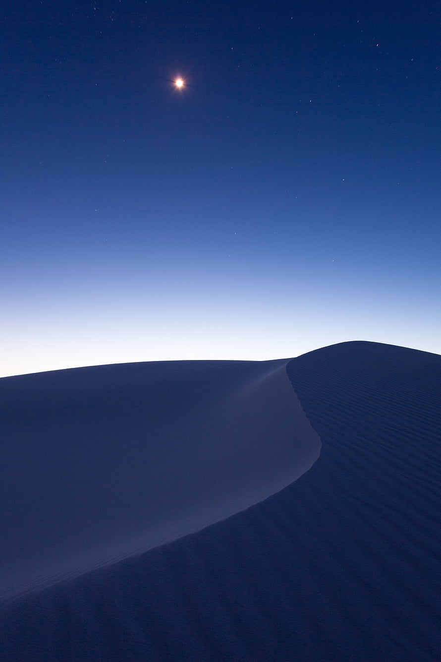 Minimalist Desert Dunes Under a Starry Night Sky with a Bright Celestial Body HD phone wallpaper
