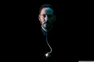 Keanu Reeves as John Wick in a dark cinematic portrait with a glowing sparkler HD wallpaper