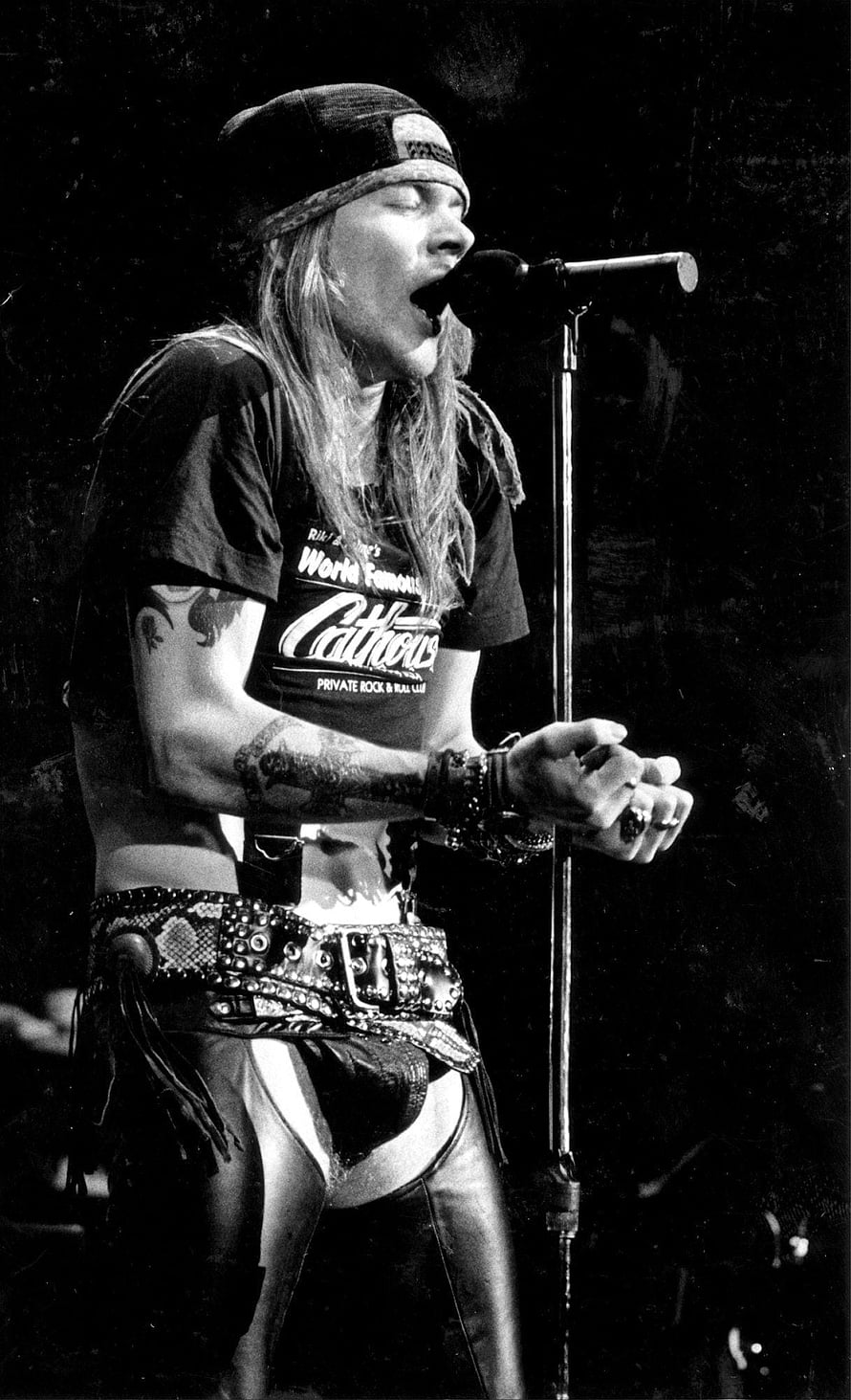 Axl Rose performing live on stage in black and white with microphone and bandana HD phone wallpaper