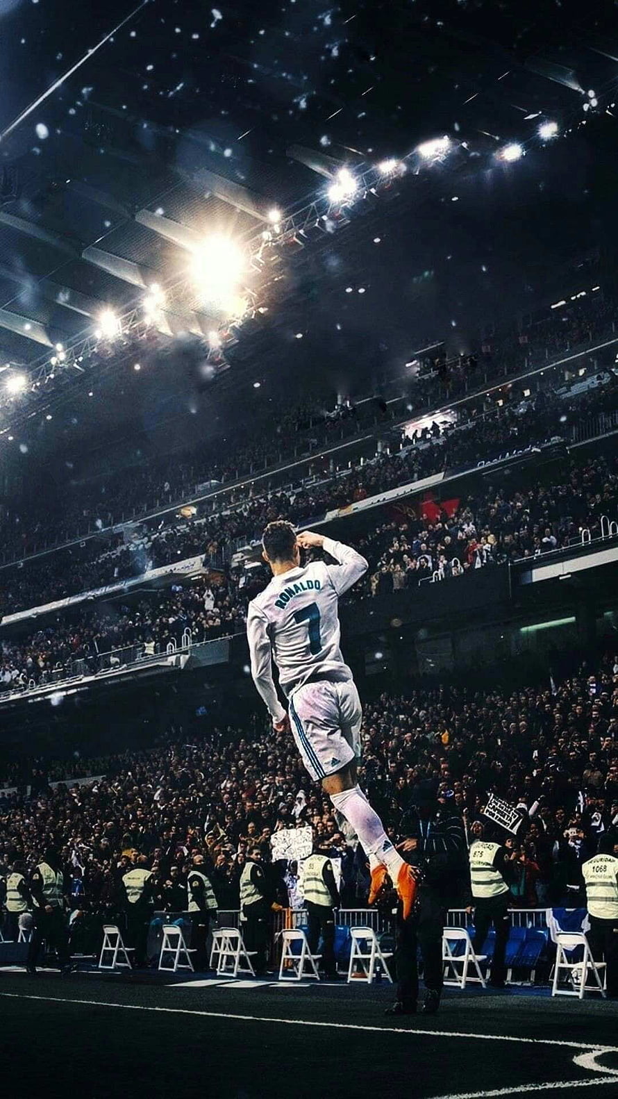 Cristiano Ronaldo performing his signature jump celebration in a white Real Madrid kit under stadium lights HD phone wallpaper