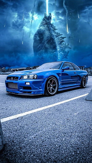 Blue Nissan Skyline R34 GT-R Parked Before a Towering Godzilla Silhouette HD phone wallpaper