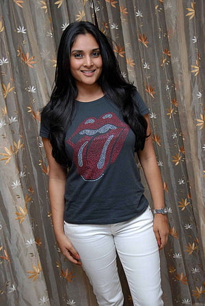Divya Spandana in a dark graphic t-shirt and white jeans HD phone wallpaper