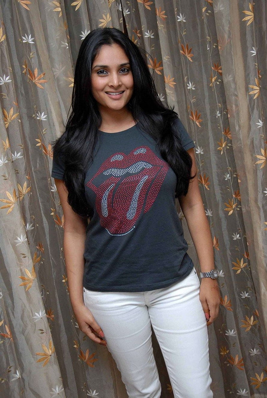 Divya Spandana in a dark graphic t-shirt and white jeans HD phone wallpaper