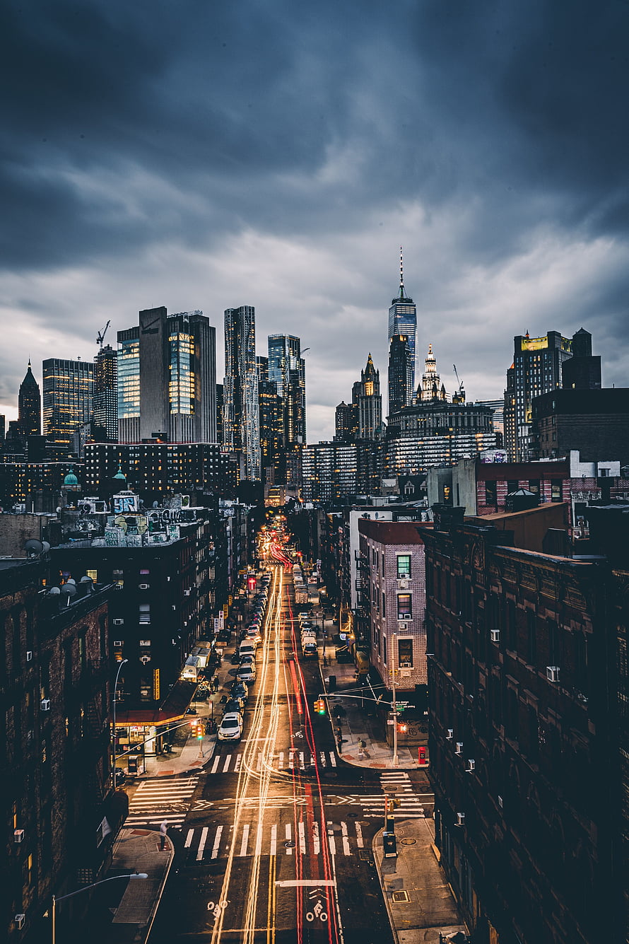 Downtown Manhattan Skyline at Dusk with Long Exposure Traffic Trails and Dramatic Storm Clouds HD phone wallpaper
