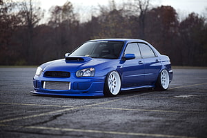 Stanced Blue Subaru Impreza WRX STI Sedan With White Wheels In Empty Parking Lot HD wallpaper