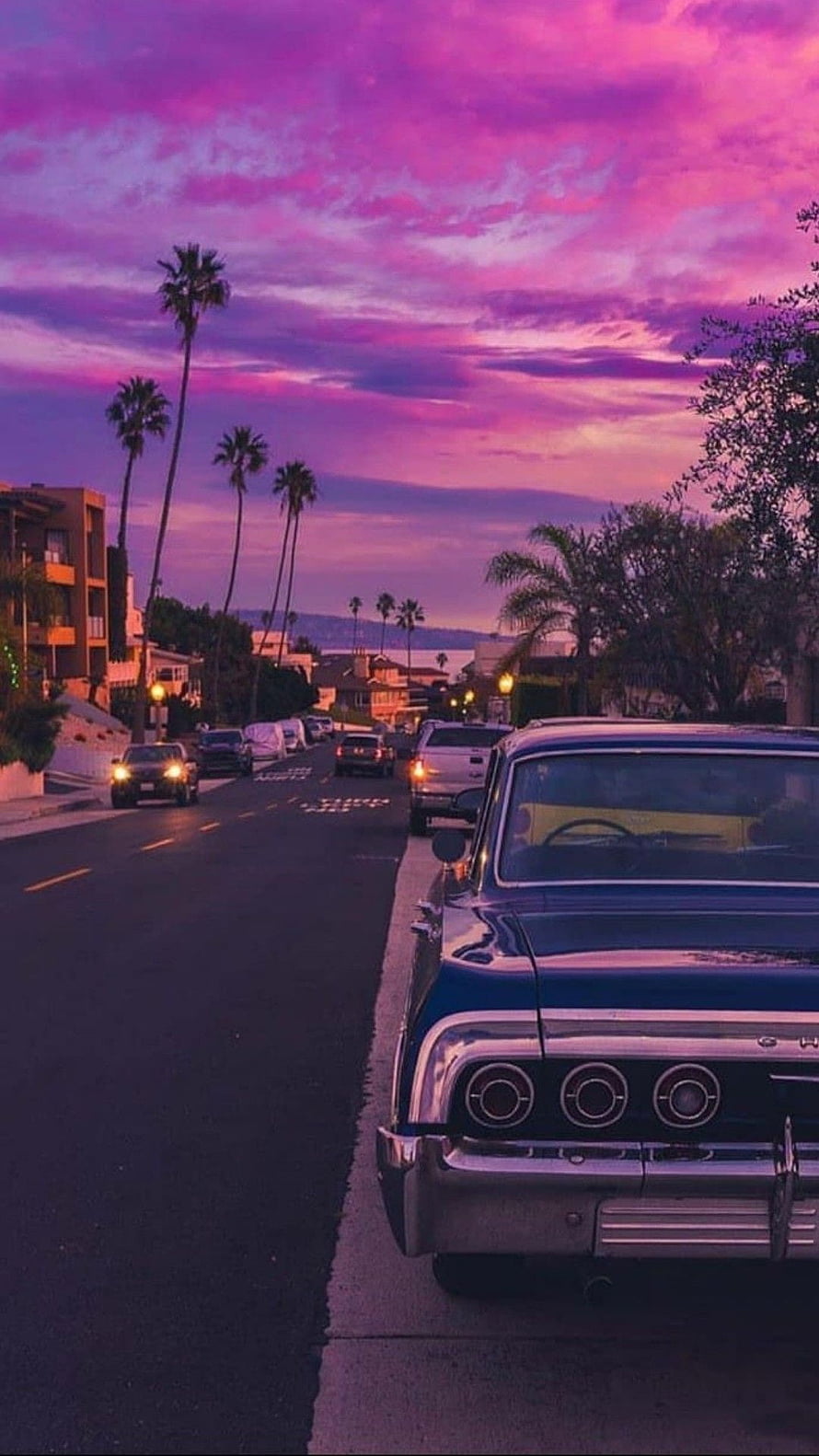 Vintage Chevrolet Classic Car Parked on Suburban Street Under Vibrant Purple Sunset Sky HD phone wallpaper