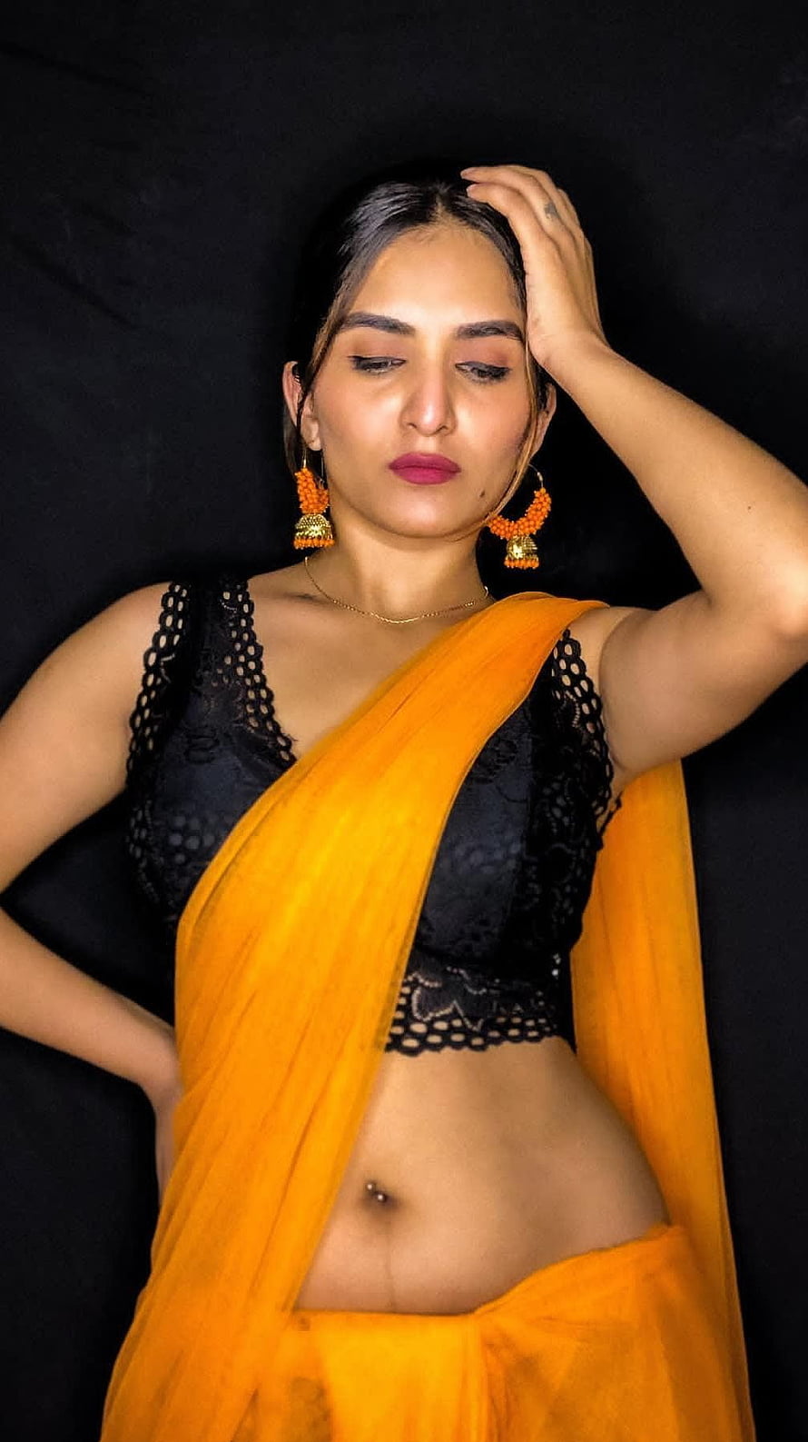 Trishaa Kamlakar in a vibrant orange saree with black lace blouse and traditional jhumka earrings HD phone wallpaper