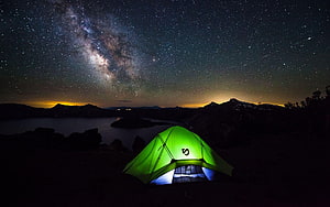 Illuminated Green Tent Under the Milky Way Galaxy Over a Mountain Lake at Night HD wallpaper