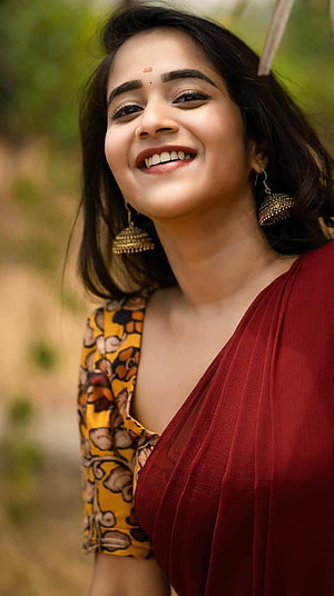 Deepti Sunaina in a maroon saree with gold jhumka earrings and floral blouse HD phone wallpaper