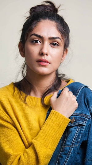 Mrunal Thakur in a mustard yellow sweater and denim jacket with a casual top bun hairstyle HD phone wallpaper