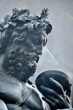 Close-up of a weathered Poseidon statue with laurel crown and spider webs HD phone wallpaper
