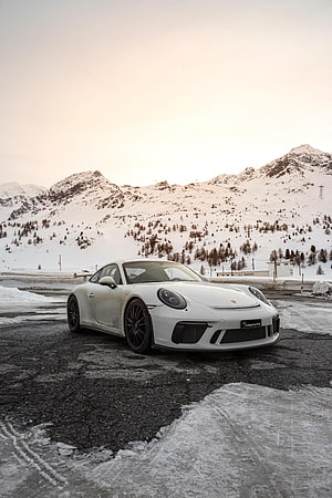 White Porsche 911 Turbo S parked on a snowy mountain road at dusk HD phone wallpaper