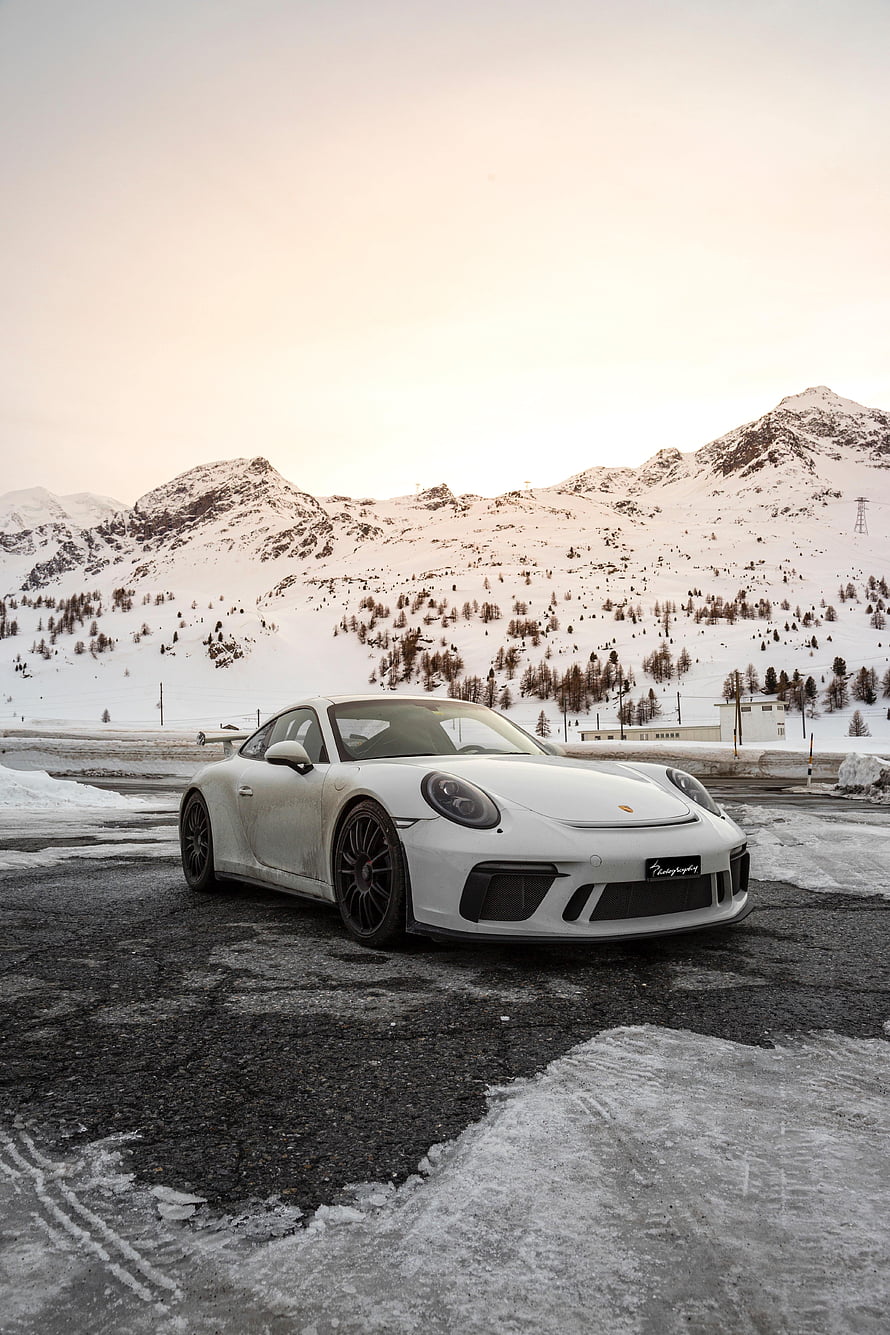 White Porsche 911 Turbo S parked on a snowy mountain road at dusk HD phone wallpaper