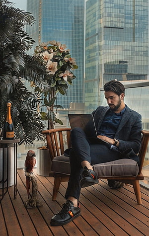 Businessman Working on Laptop in Modern High-Rise Apartment with City Skyline View HD phone wallpaper