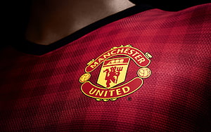Manchester United Home Kit Crest Close-Up on Red Jersey Fabric HD wallpaper