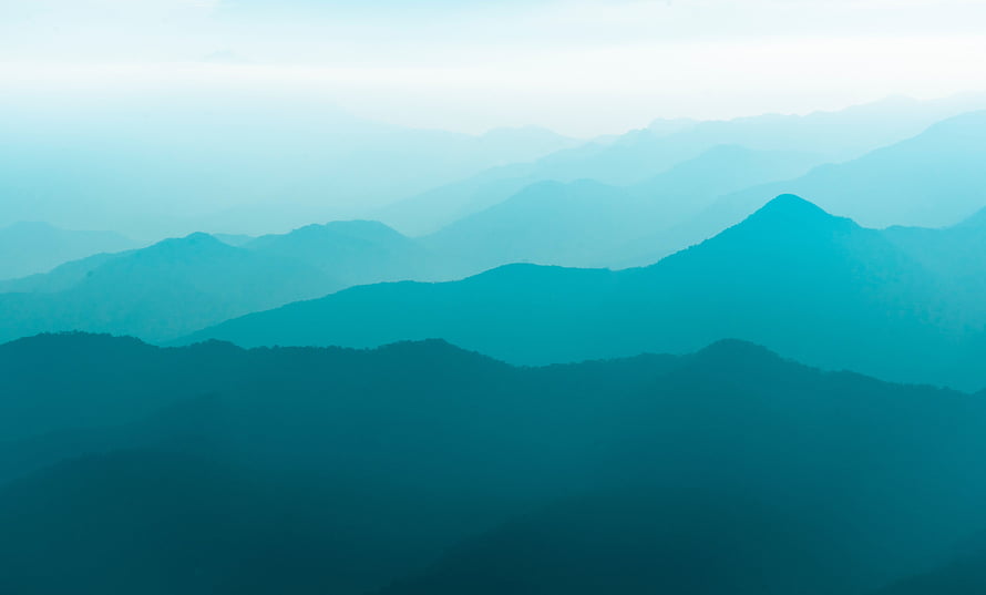 Layered Mountain Range Silhouettes in Teal Mist and Atmospheric Depth HD wallpaper
