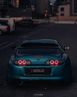 Rear View of a Teal Toyota Supra A80 with Custom Taillights in an Urban Setting at Dusk HD phone wallpaper