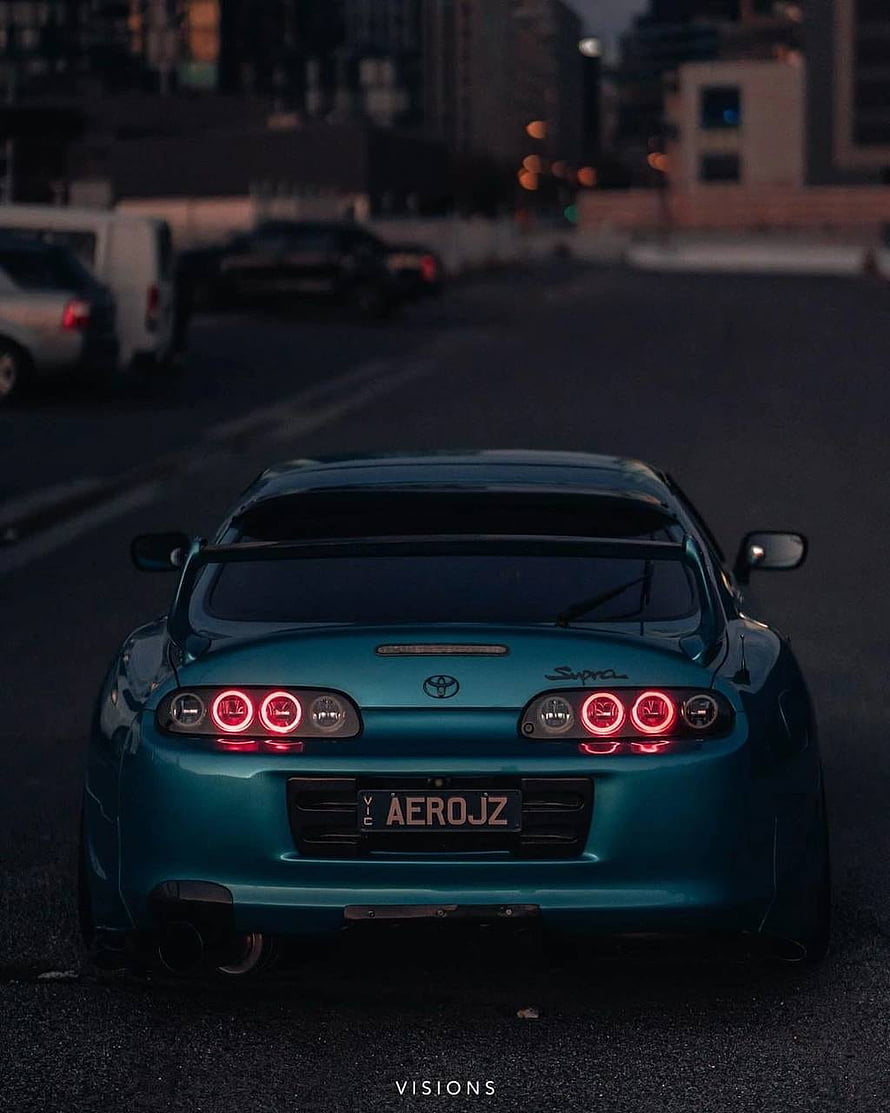 Rear View of a Teal Toyota Supra A80 with Custom Taillights in an Urban Setting at Dusk HD phone wallpaper