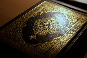 Ornate Gold-Embossed Quran Cover with Intricate Islamic Calligraphy and Geometric Patterns HD wallpaper