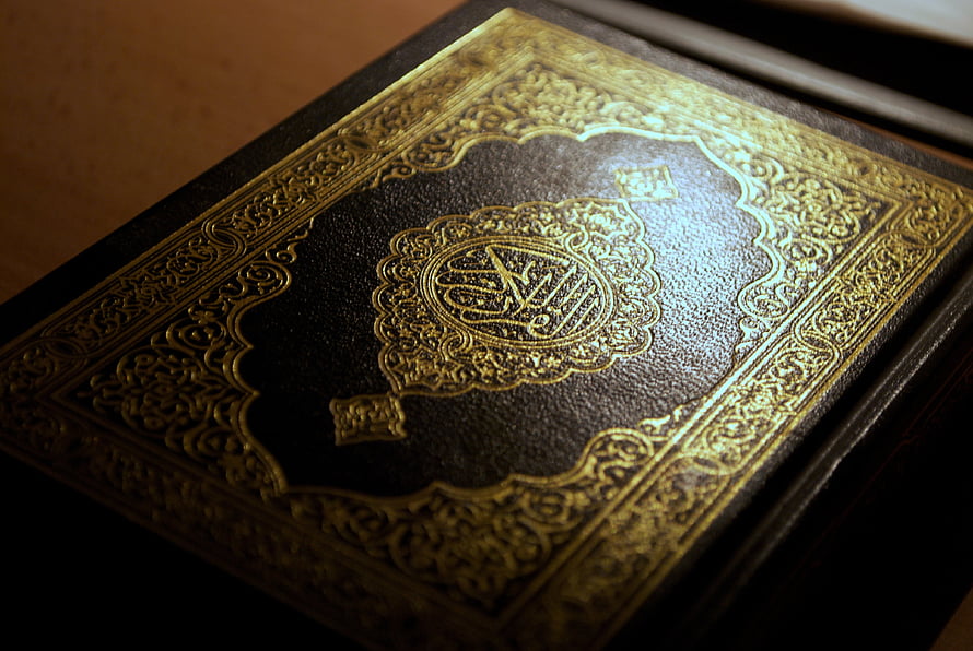 Ornate Gold-Embossed Quran Cover with Intricate Islamic Calligraphy and Geometric Patterns HD wallpaper
