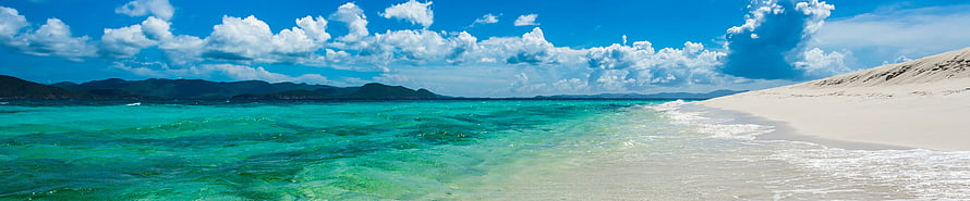 Pristine Tropical Beach with Turquoise Waters and White Sand Dunes Under a Bright Blue Sky HD wallpaper