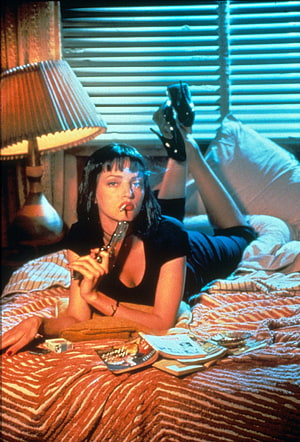 Uma Thurman as Mia Wallace in Pulp Fiction lying on a bed with a gun HD phone wallpaper
