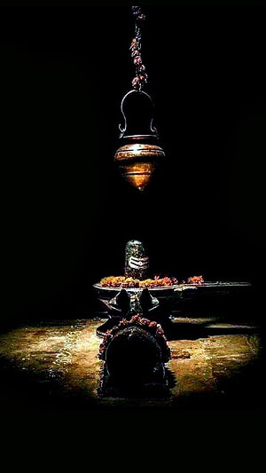 Sacred Shiva Lingam with Hanging Kalash and Floral Offerings in Dramatic Low Light HD phone wallpaper