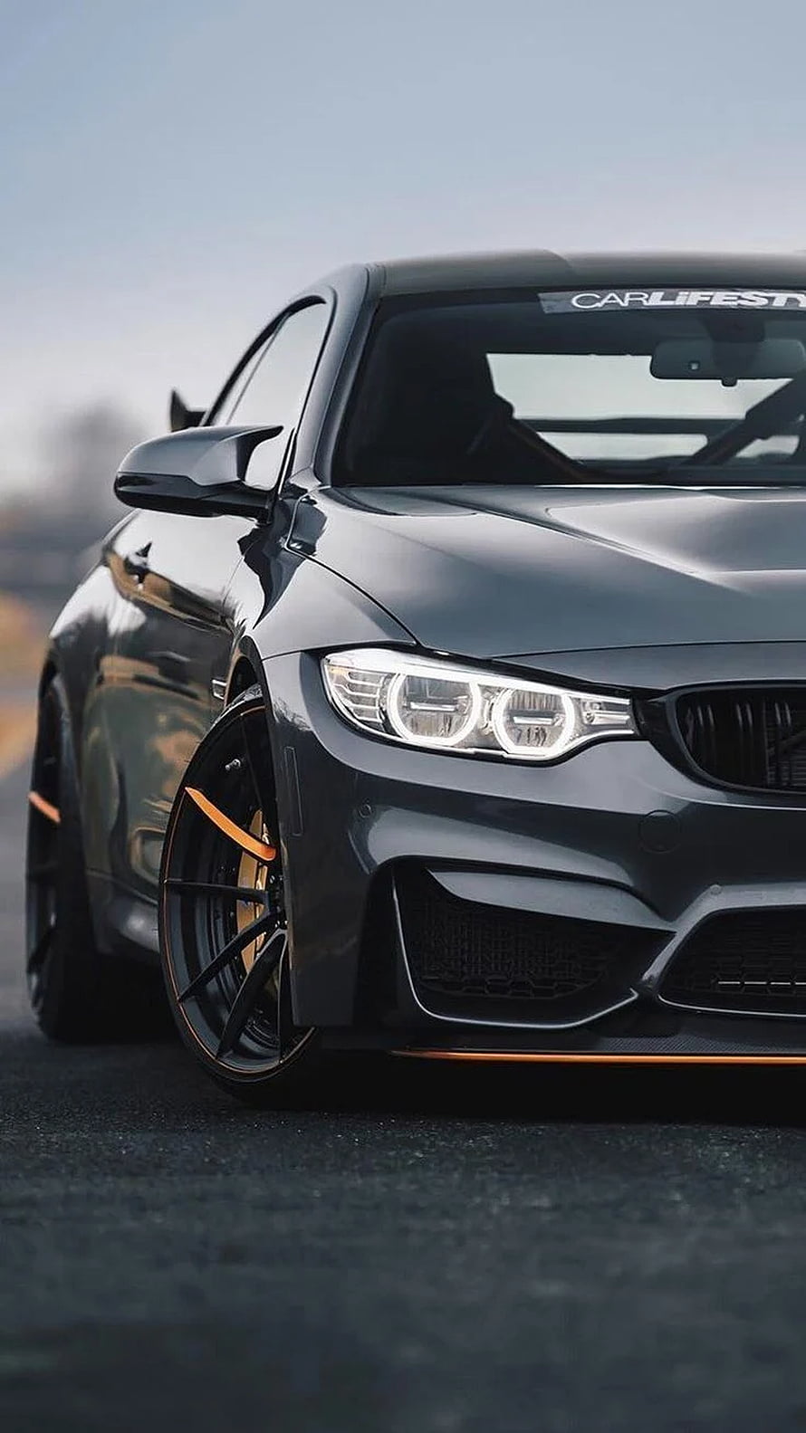 Black BMW M4 Coupe with Orange Accents and Custom Multi-Spoke Wheels HD phone wallpaper