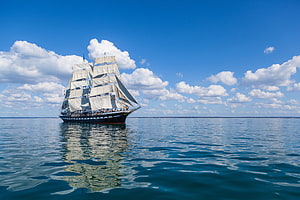 Classic Tall Ship Sailing on Calm Blue Waters Under a Bright Sky HD wallpaper
