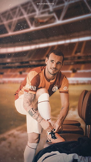 Wesley Sneijder in Galatasaray Kit Tying Boots on the Pitch HD phone wallpaper