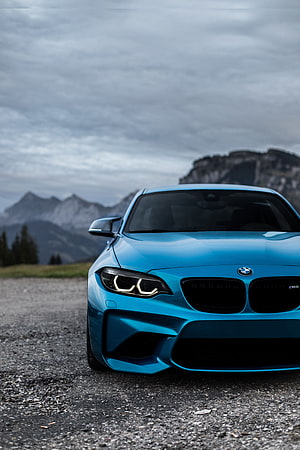 Front View of a Blue BMW M2 Coupe Parked on a Gravel Road with Mountain Backdrop HD phone wallpaper