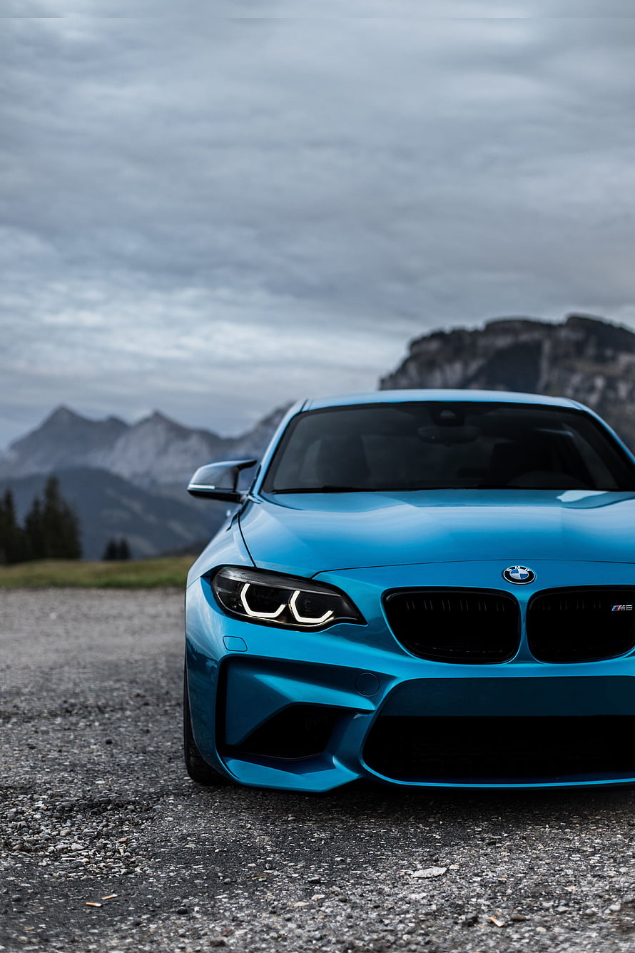 Front View of a Blue BMW M2 Coupe Parked on a Gravel Road with Mountain Backdrop HD phone wallpaper