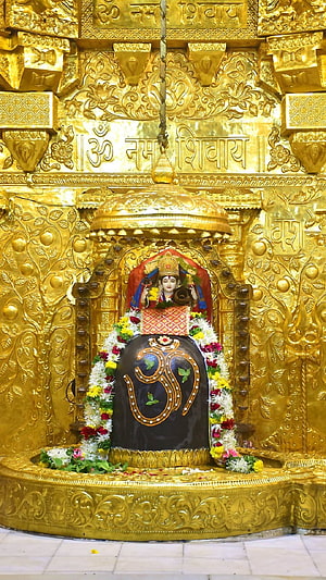 Somnath Mahadev Temple Shiva Lingam with Ornate Gold Carvings and Floral Garlands HD phone wallpaper