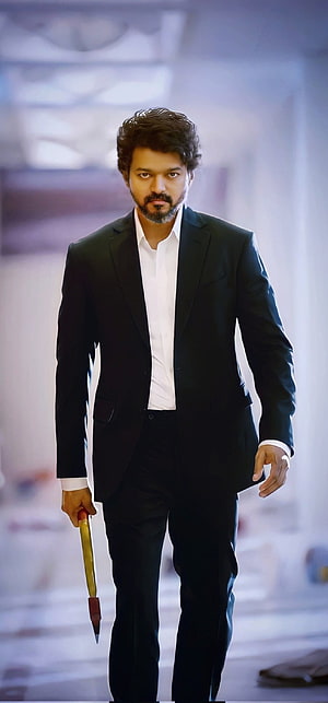 Thalapathy Vijay in a black suit holding a dagger in a cinematic corridor HD phone wallpaper