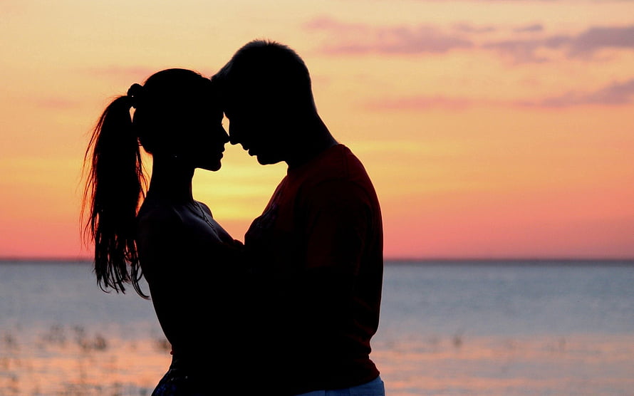 Romantic Couple Silhouette Embracing at Sunset by the Ocean HD wallpaper