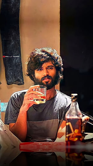 Vijay Deverakonda as Arjun Reddy Holding a Glass of Whiskey in a Dimly Lit Scene HD phone wallpaper