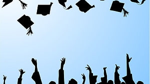 Silhouette of Graduates Tossing Caps Against a Clear Blue Sky HD wallpaper