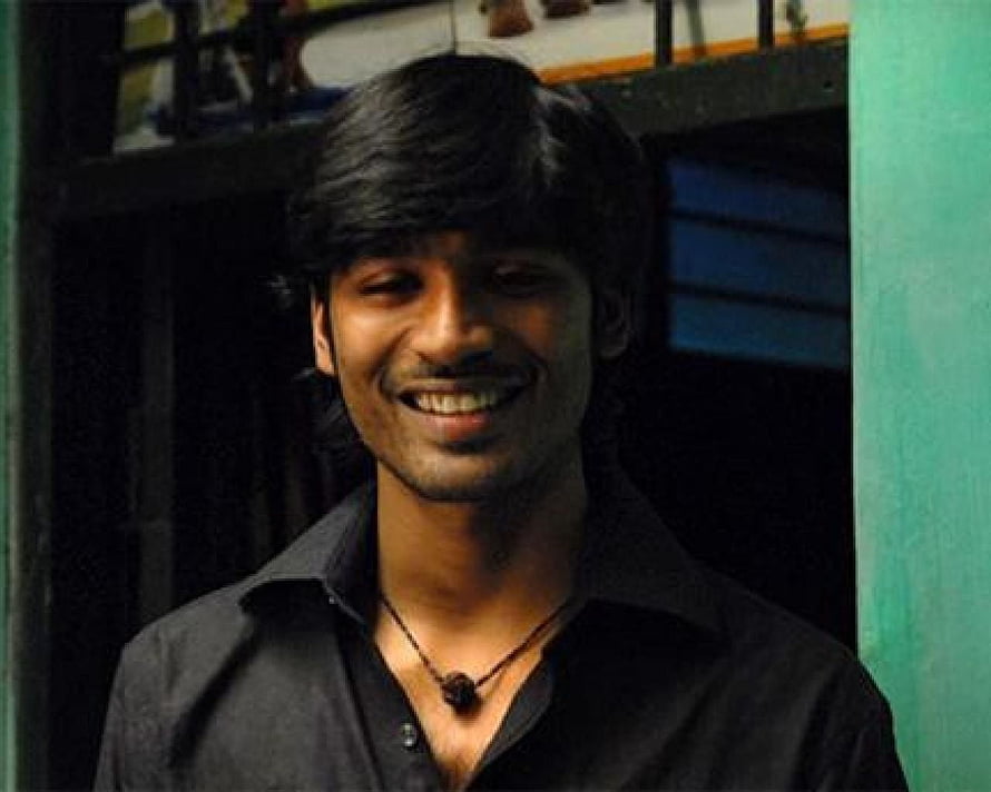 Dhanush smiling portrait in dark shirt with pendant necklace HD wallpaper