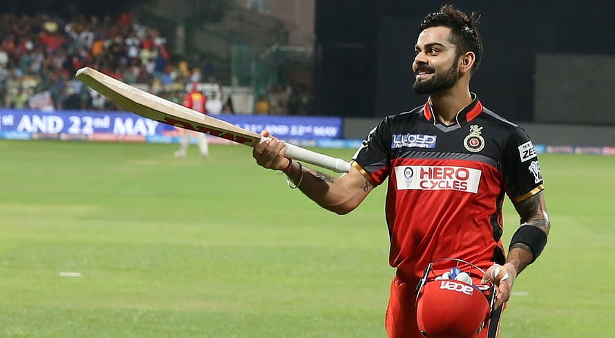 Virat Kohli in Royal Challengers Bangalore kit holding bat on cricket field HD wallpaper