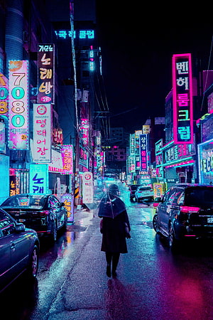 Lone figure with umbrella walking through rain-slicked neon-lit Korean street at night HD phone wallpaper