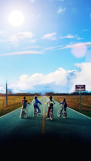 Stranger Things Four Boys Riding Bikes on a Rural Road Under a Bright Blue Sky HD phone wallpaper