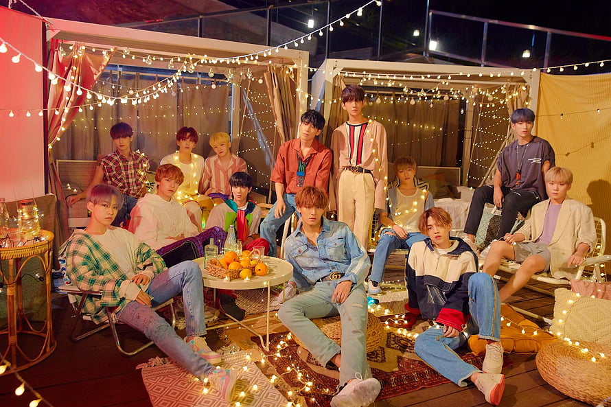 Seventeen K-Pop Group in Cozy Outdoor Setting with String Lights and Casual Fashion HD wallpaper