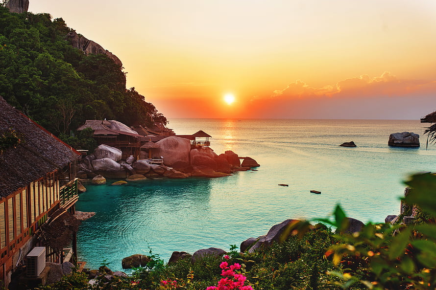 Tropical Island Sunset Over Turquoise Lagoon With Thatched Cabanas And Granite Boulders HD wallpaper