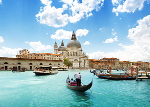 Gondola gliding through the turquoise waters of Venice's Grand Canal with the Basilica di Santa Maria della Salute in the background HD wallpaper
